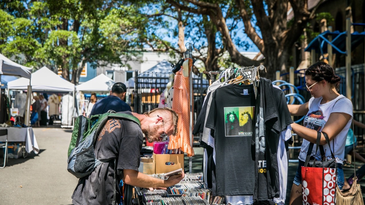 People looking through clothing on racks and CDs through boxes at the Rozelle Collectors Markets