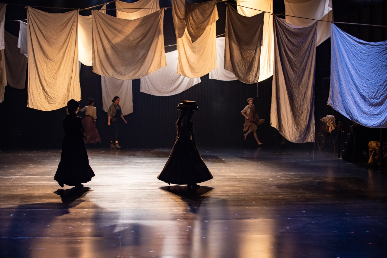 photo of women in shadow hanging out the washing