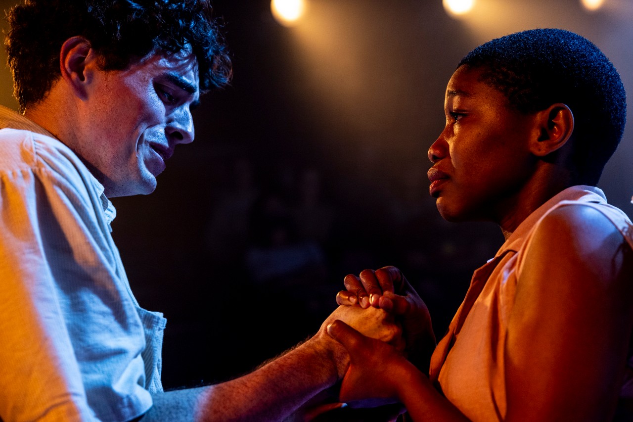 a woman and man hold hands, they are crying