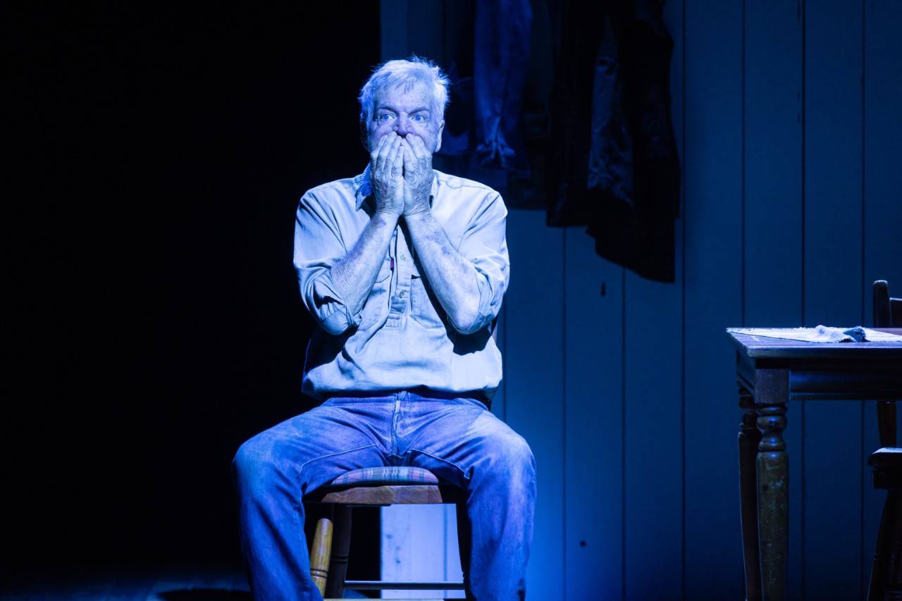 an actor on stage, a man, looking upset