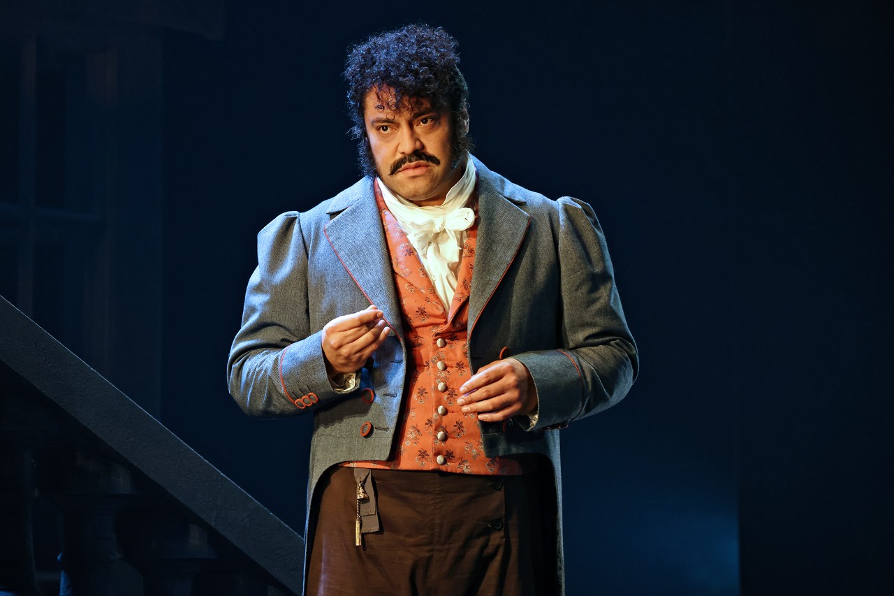 a man in very fancy Victorian costume is pointing