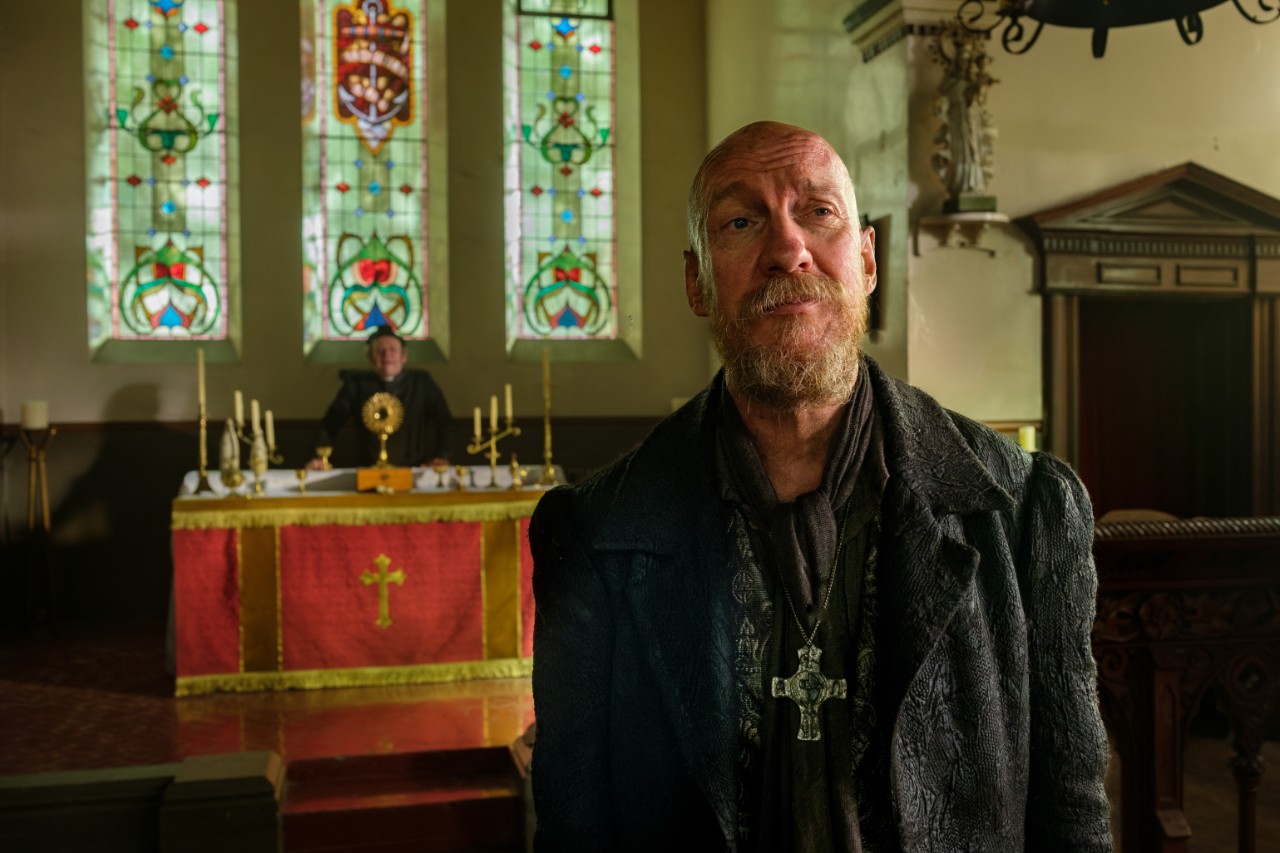 A scruffy-looking man is standing in a church, this is Fagin. 