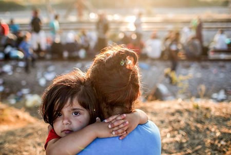 A mother holds child in her arms. 