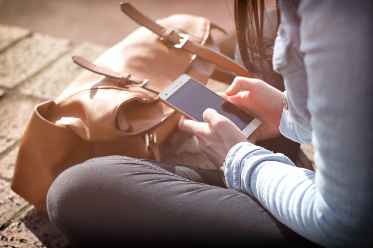 A young woman using her smartphone. Image: Pexels.