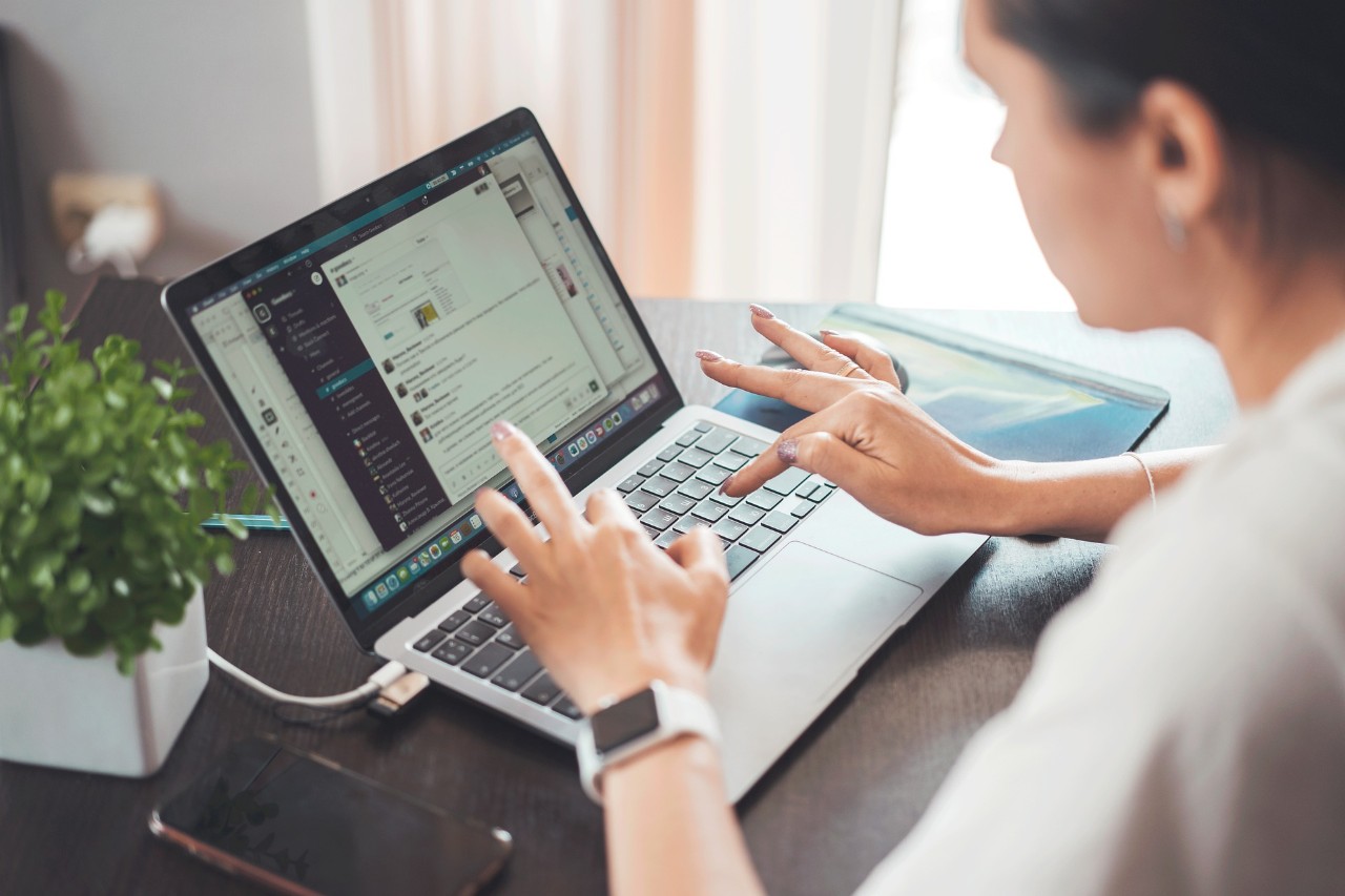 photo of a woman's hand working on a laptop
