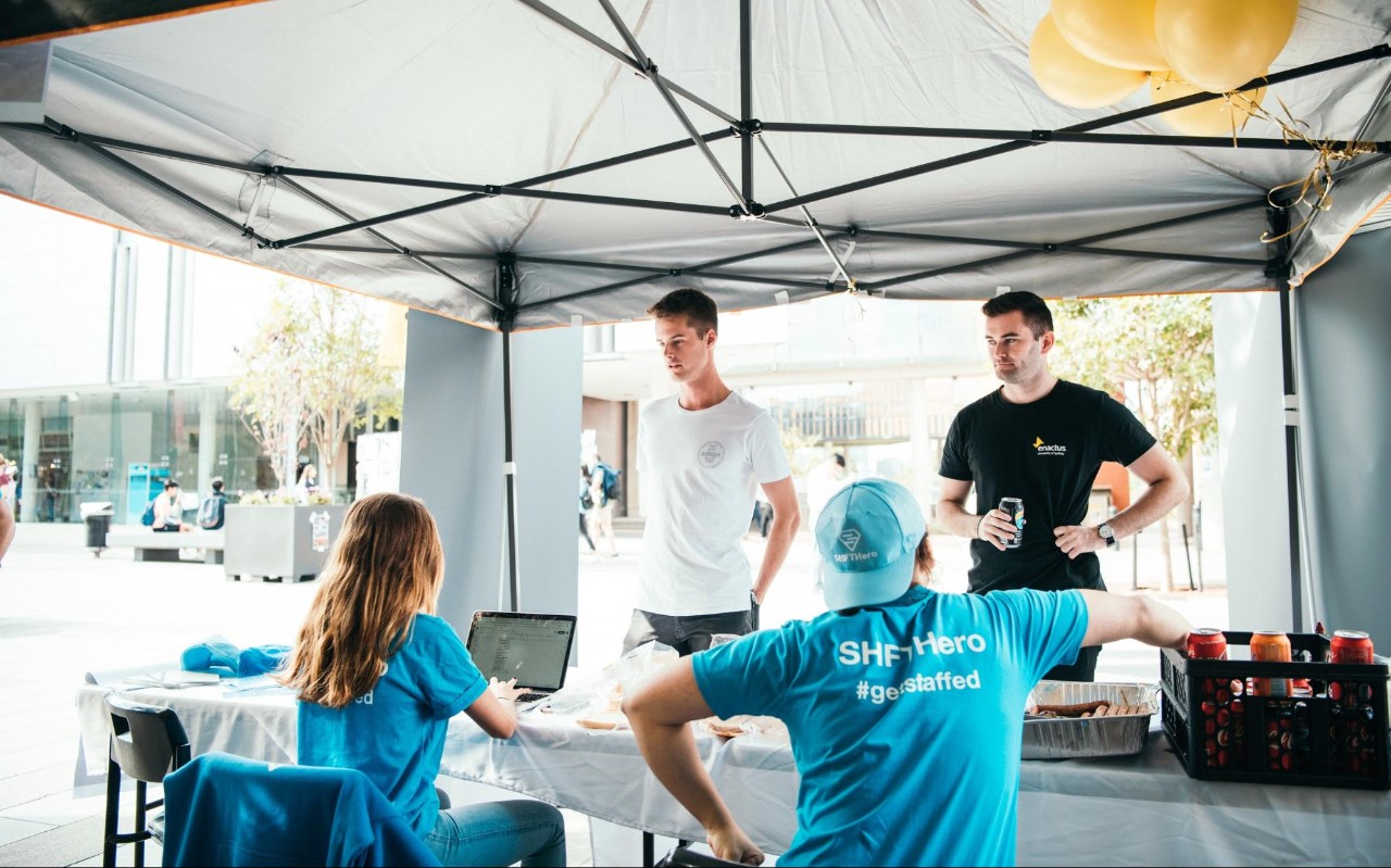 Tomas Moran with three students in the Enactus tent
