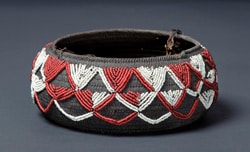 Brown ceremonial basket with red and white bead embellishments