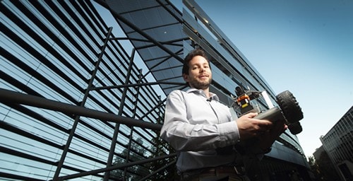 Associate Professor Fabio Ramos holding intelligent systems prototype