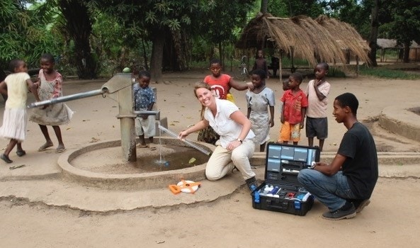 Dr Jacqueline Thomas next to a well in village