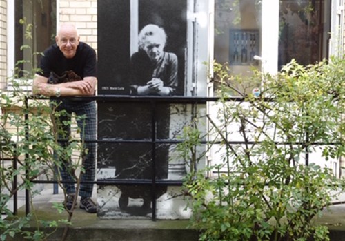 Dr Karl Kruszelnicki with an historical image of Marie Curie
