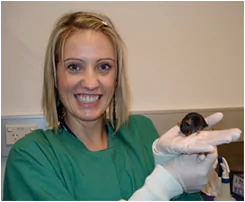 A student holding a rat in the Behavioural Pharmacology Laboratory