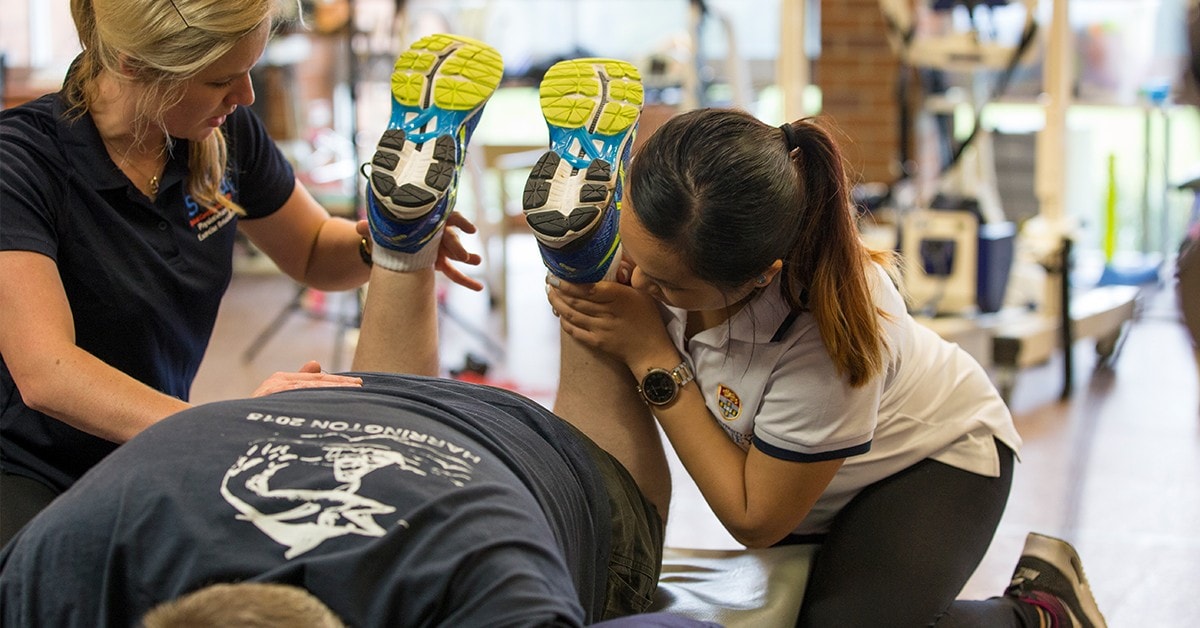 A physio stretching a patients leg