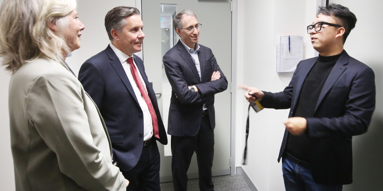 Officials standing in a group, welcomed to a facility