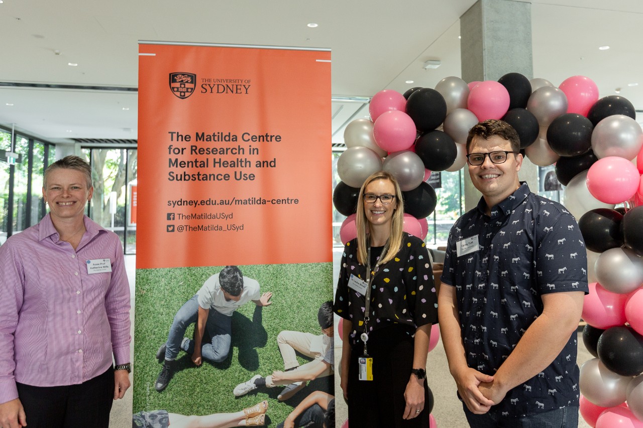 Louise Birrell, Katherine Mills and Corey Tutt standing in front of a sign opening the Matilda Centre in 2018. 