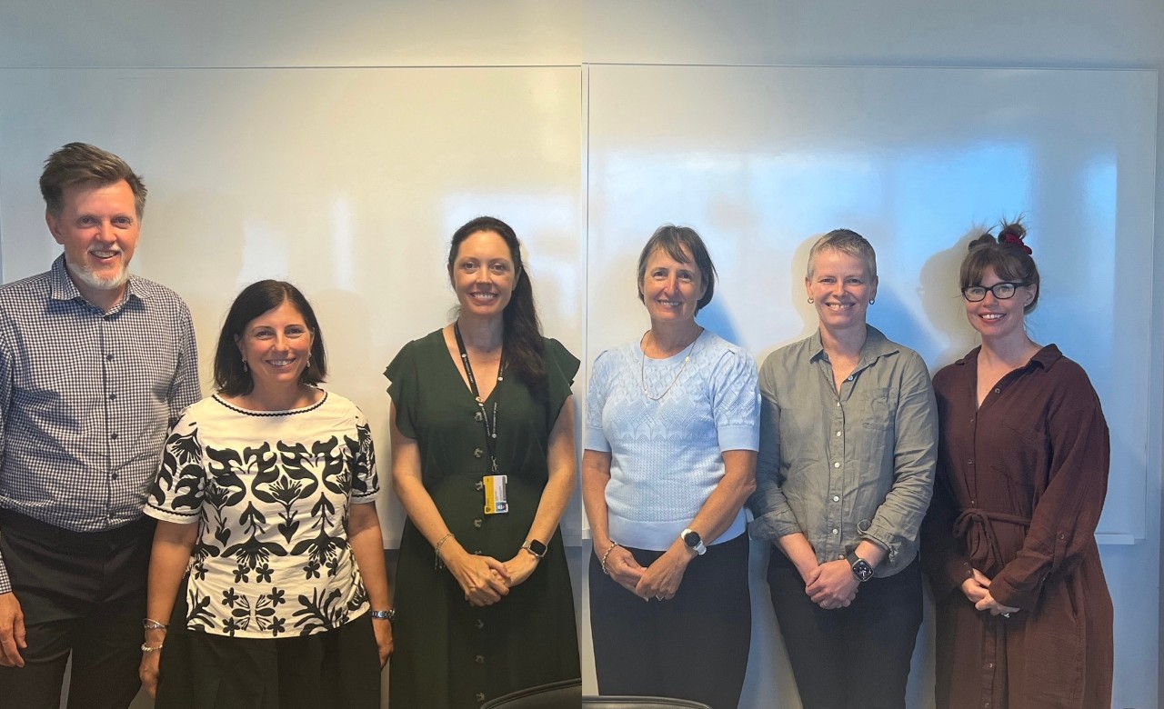 five people stand in front of a white background 