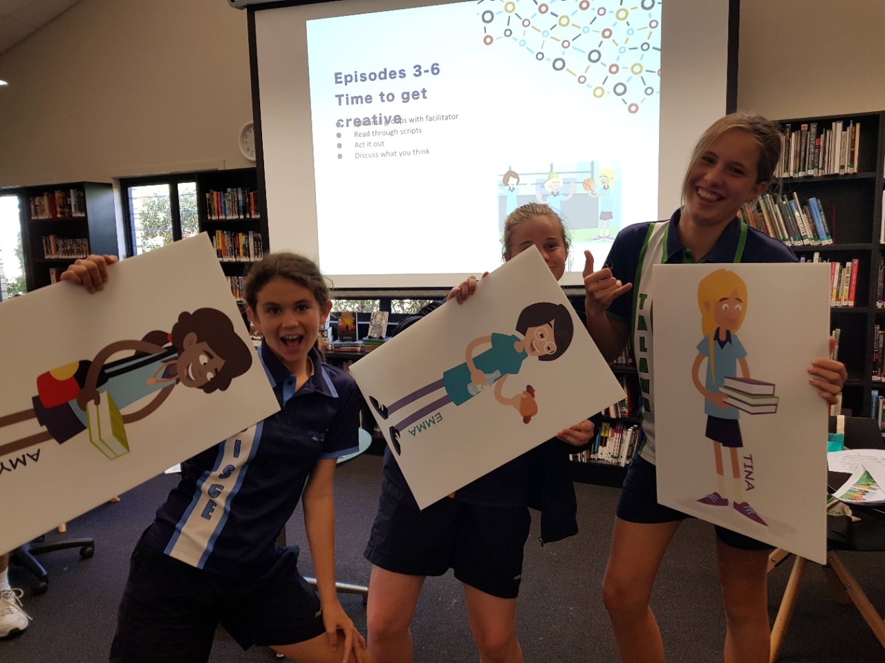 Students holding print out of characters they created for Strong & Deadly Futures