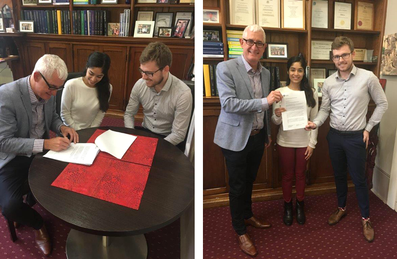 Dean and students signing the document