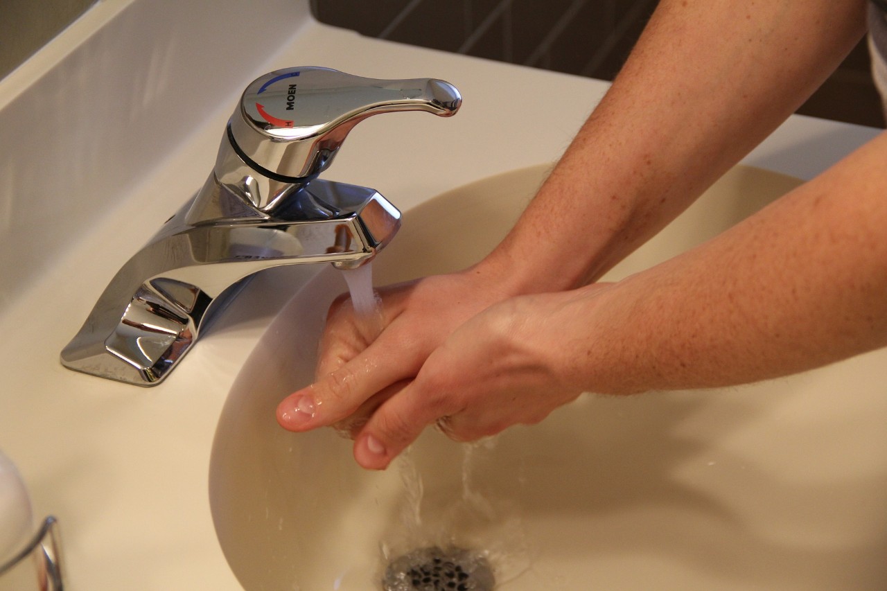 Hands being washed in a handbasin with a running tap