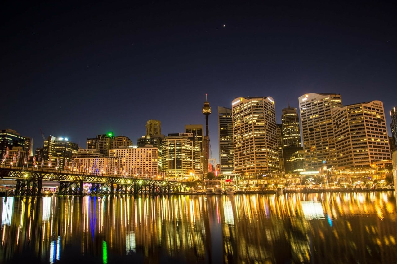 Sydney Harbour at night, lights reflected in the water. 