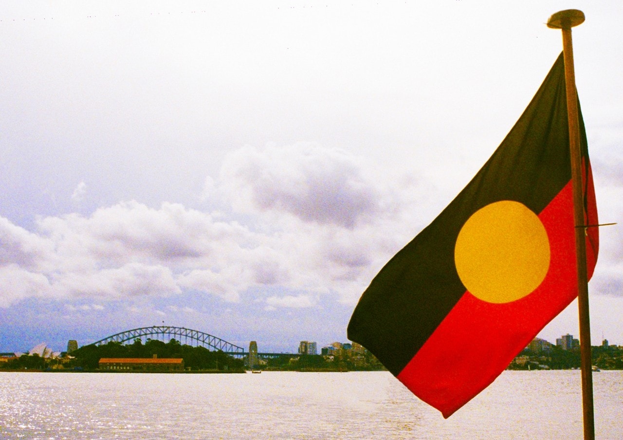 A photo of an Aboriginal flag with the Harbour Bridge in the background.