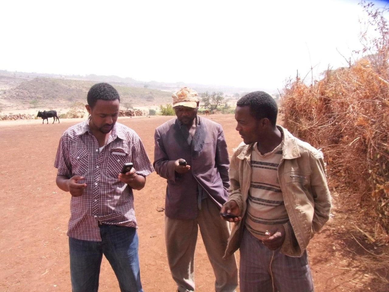 Ethiopian farmers exchange phone numbers with a research assistant. Photo: Petr Matous.