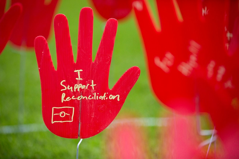 A plastic hand with 'I support Reconciliation' written on it