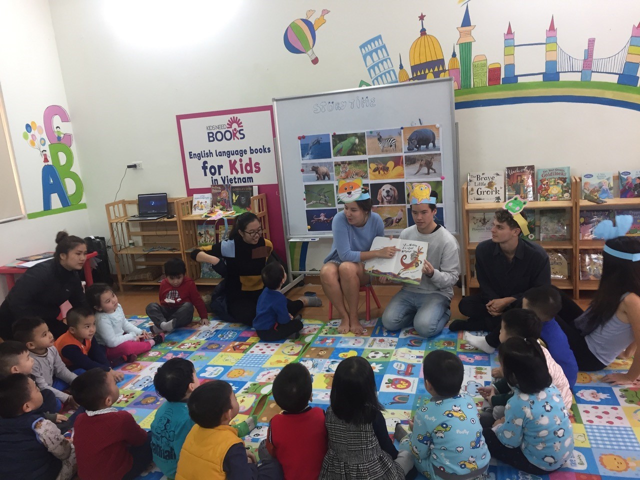 University of Sydney students (L-R) Louisa, Mike, Max and Natasha, leading story time with Vietnamese children at the Kids Needs Books social enterprise in Hanoi.