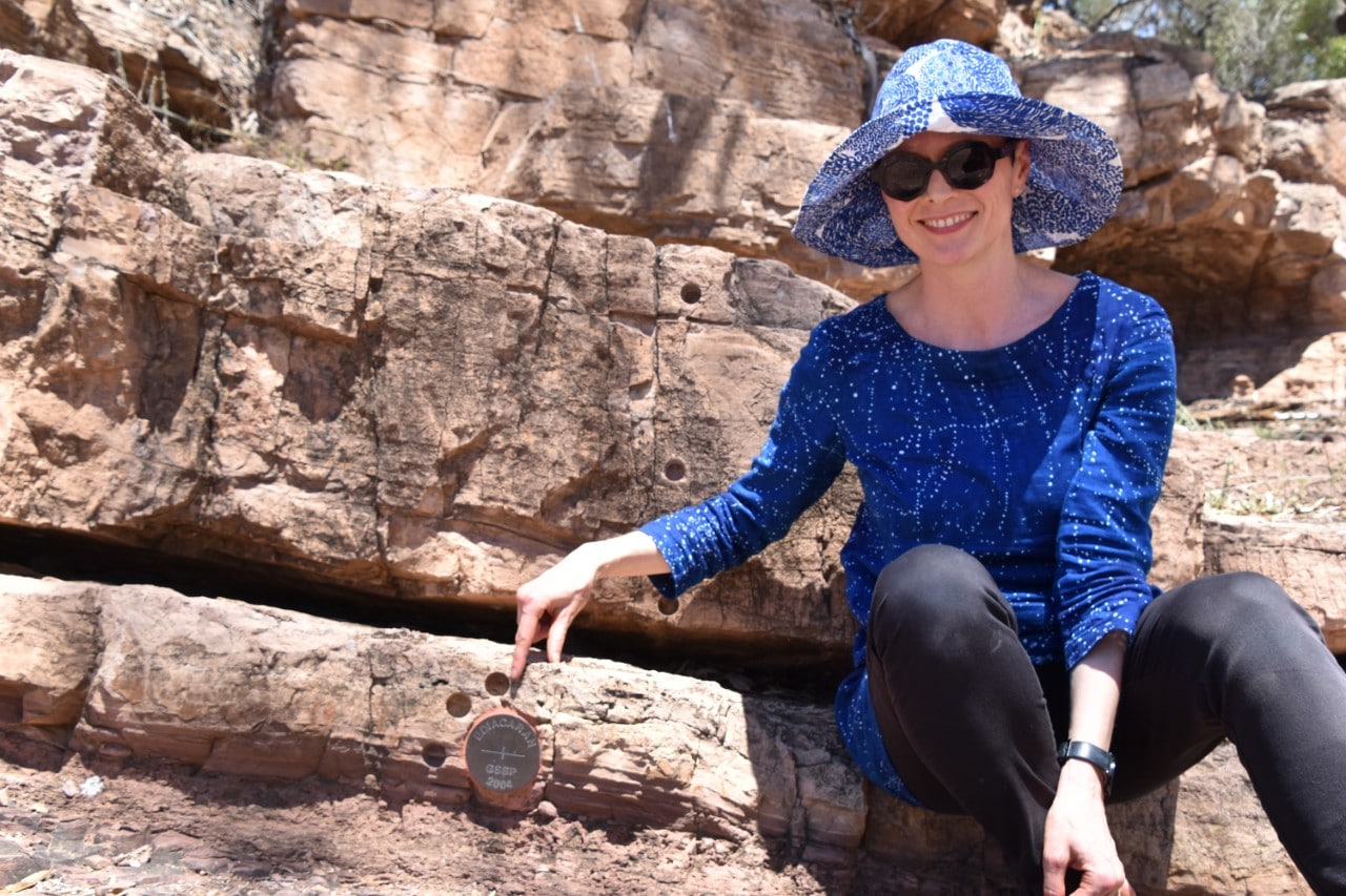 Dr Adriana Dutkiewicz pointing to the 'golden spike' in the Flinders Ranges marking the base of the Ediacaran system, a geological period that started 635 million years ago.