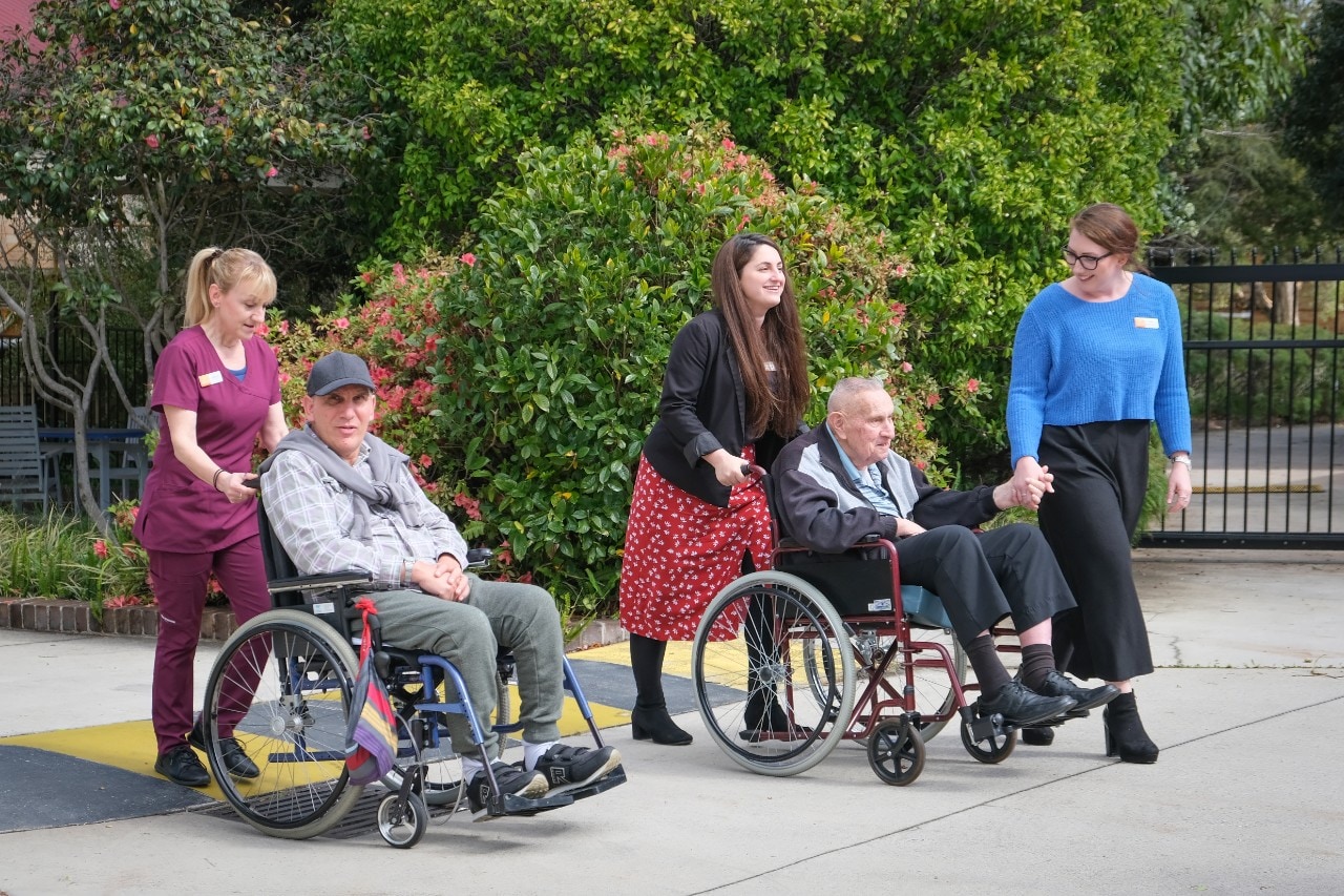 Students and residents in wheelchairs or walking up hill