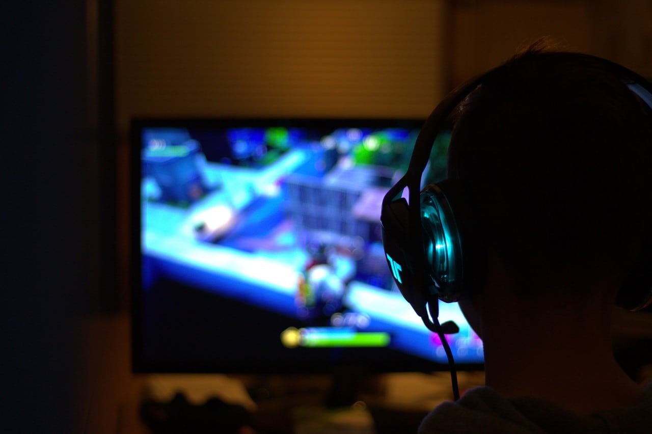 photo of a child in the dark playing video games 