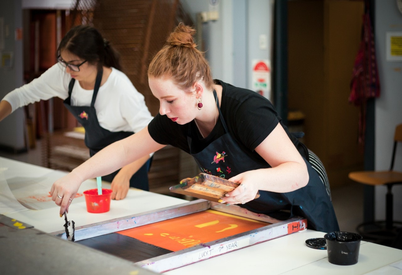 photo of a young student working on a screen print