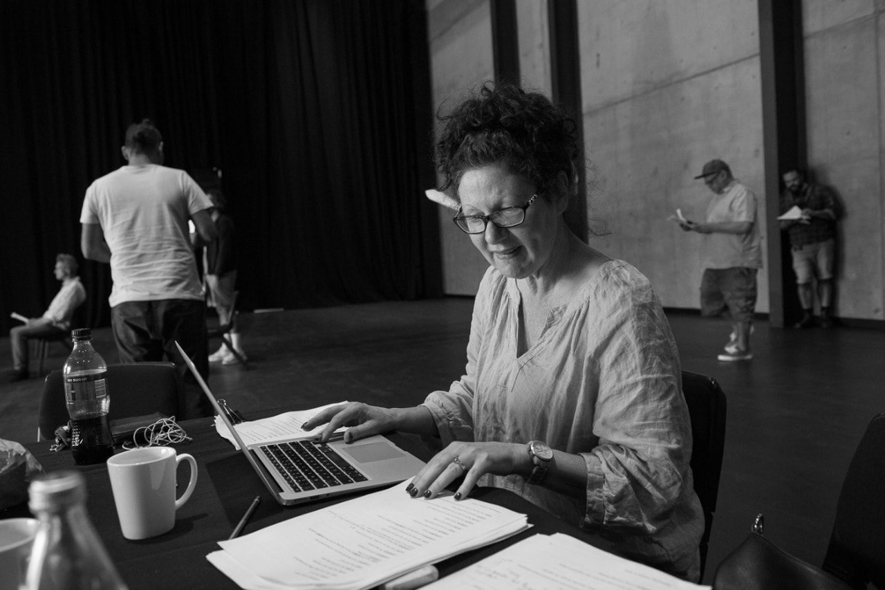 playwright and dramaturg Jane Harrison reading a script on a laptop