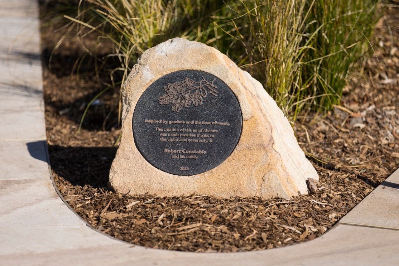 photo of a plaque with the words "inspired by gardens and a love of music"