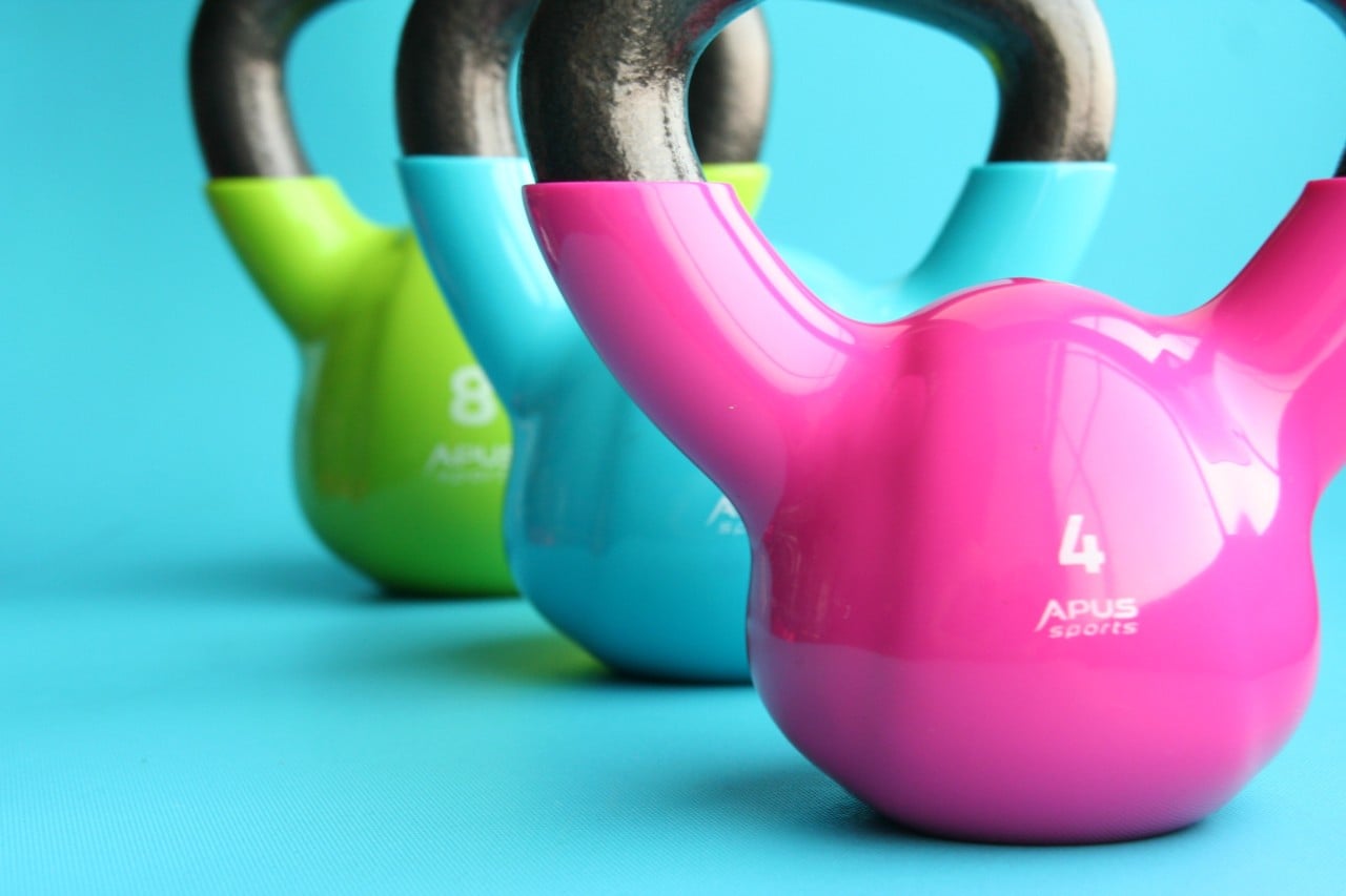Three multi-coloured kettle bells on a turquoise background
