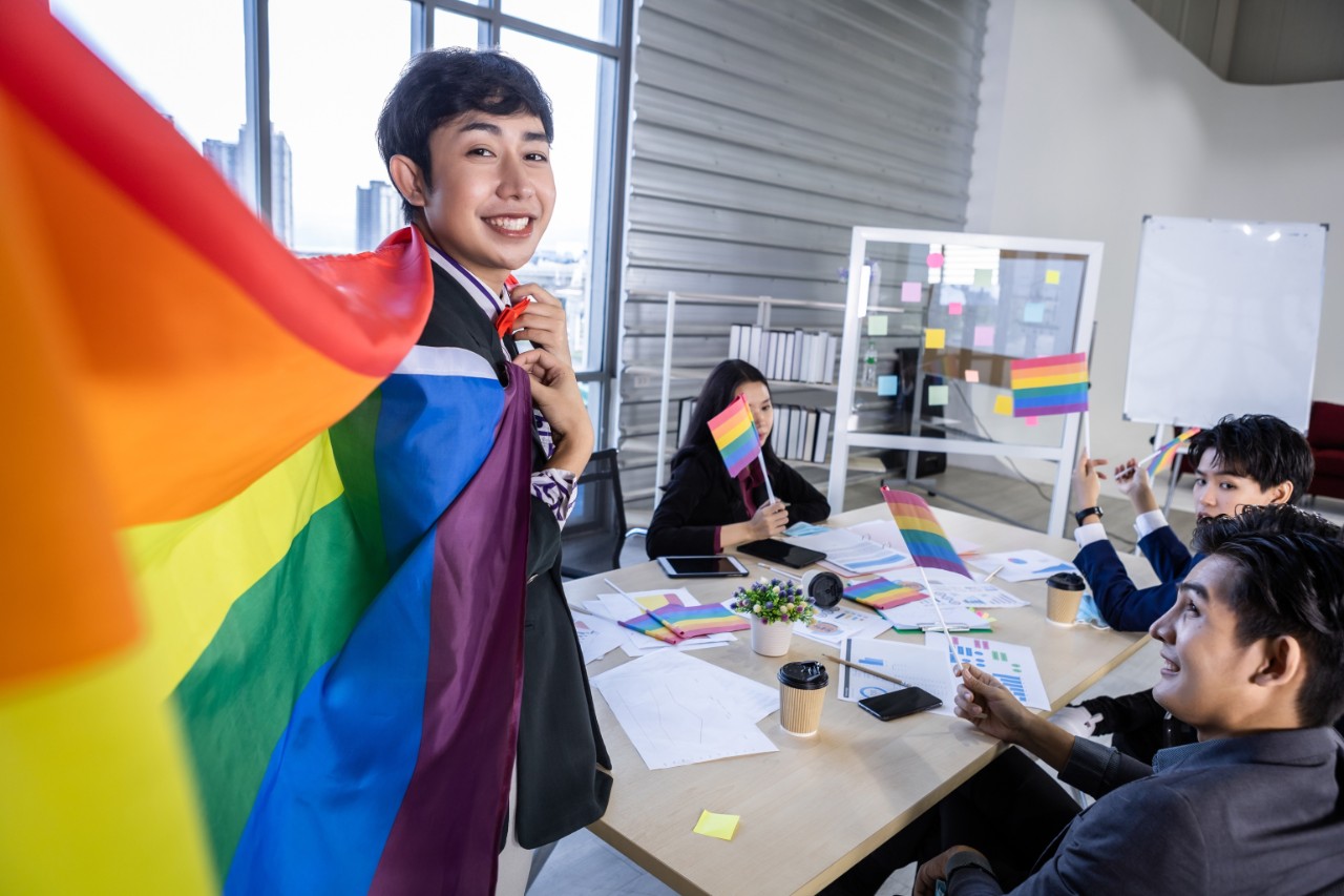 Asian business person holding a LGBT flag