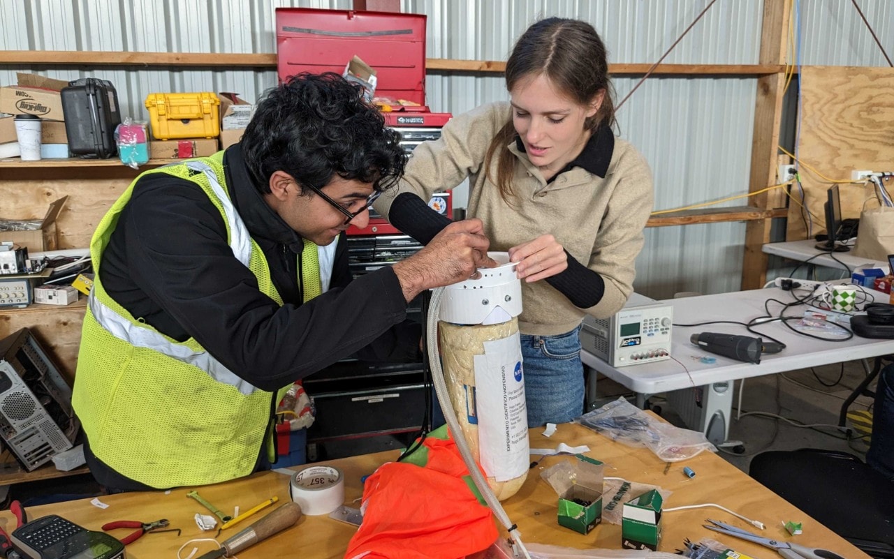 PhD candidate Ajay Gill from the University of Toronto (left) and Dr Ellen Sirks from the University of Sydney (right) working on a Data Recovery System package. [Credit: Steve Benton]