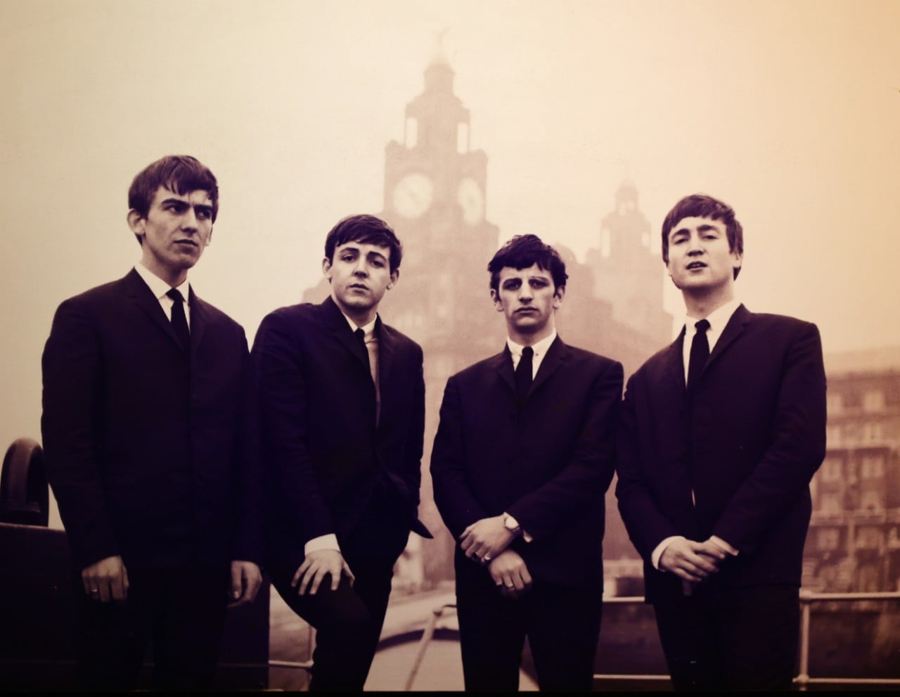 photo of four young men from the band The Beatles standing on the street in Liverpool
