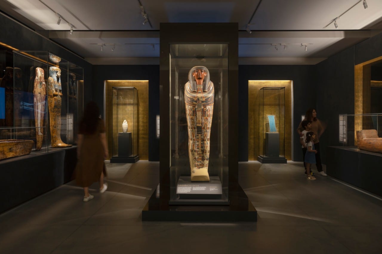 A spotlit Egyptian mummy in the Mummy Room