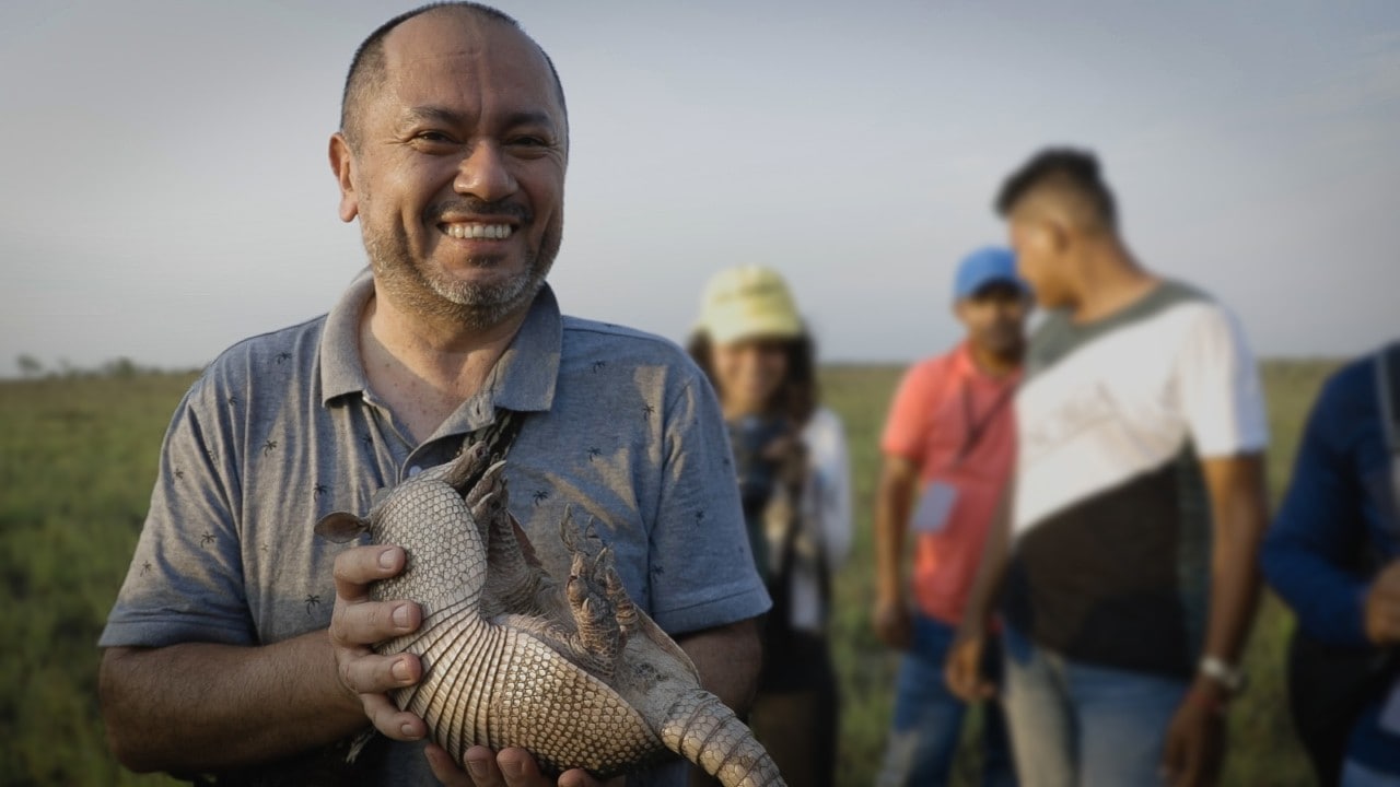 Associate Professor Jaime Gongora pictured with an armadillo during his Peace with Nature work. [Credit: Jon Spaull]