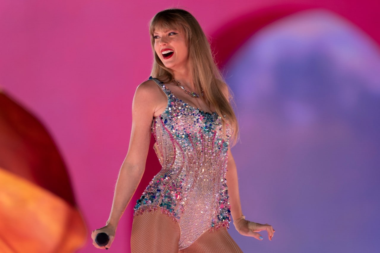 Pop singer Taylor Swift wearing a sparkling bodysuit on stage for her Eras tour. 