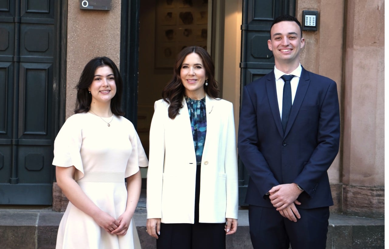 Queen Mary of Denmark stands between Crown Princess Mary Scholarship recipients, students Sophia Parada and Matthew Joffe.