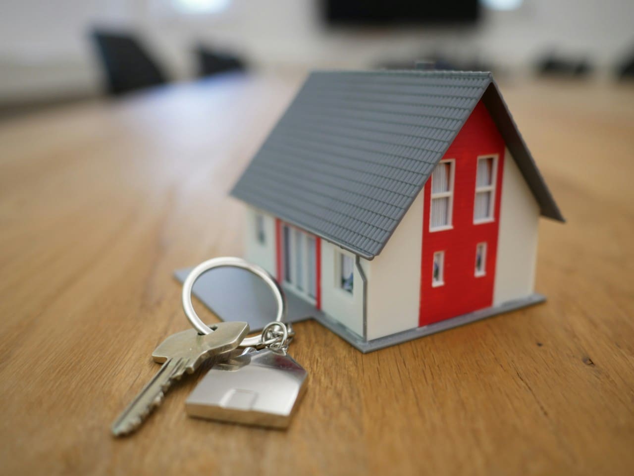 A toy house with keys in front. Image by Tierra Mallorca on Unsplash.