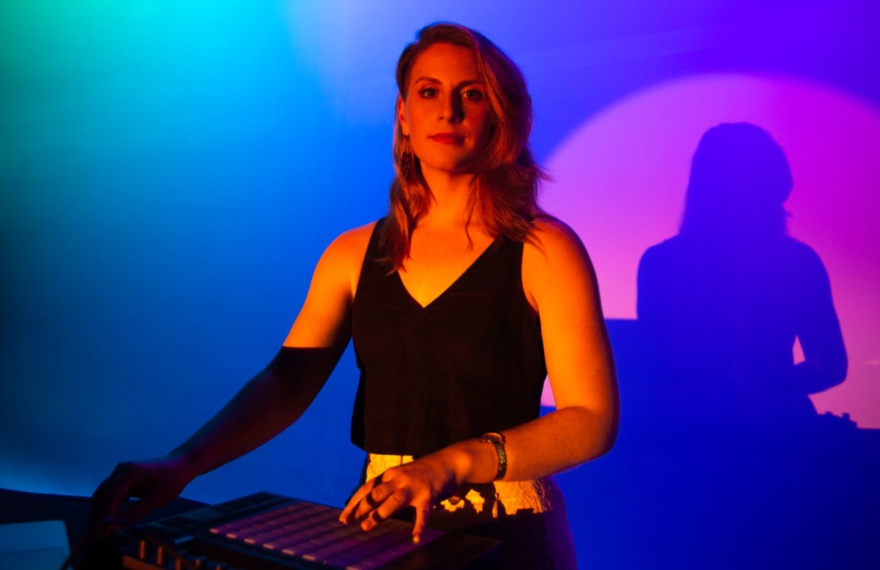 A studio headshot of Alexis Weaver with electronic music equipment