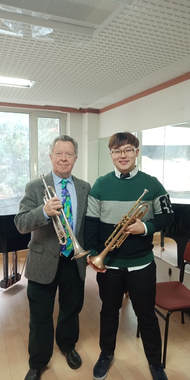 Student and teacher holding trumpets