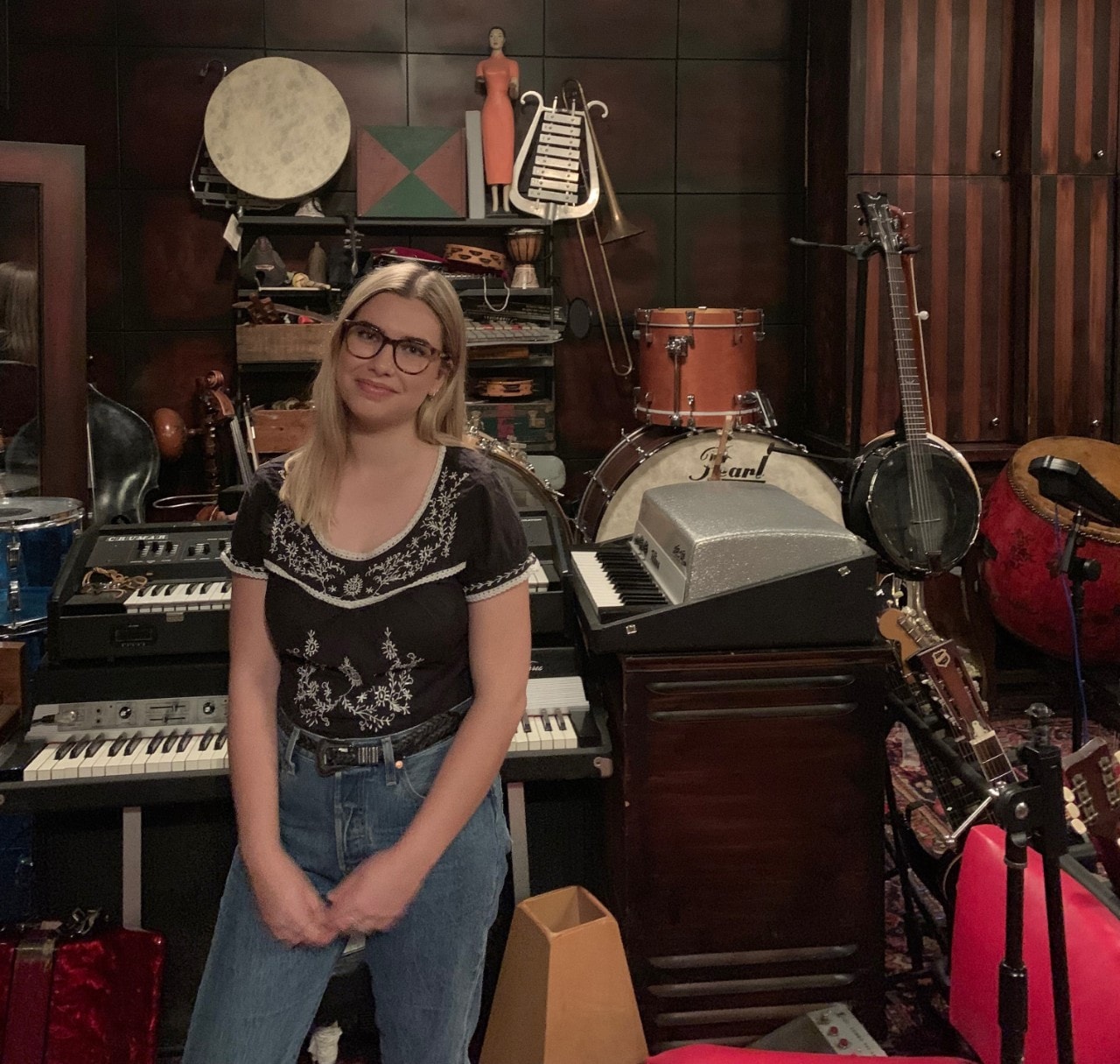 Chloe Sinclair in the Matter Music studio surrounded by musical instruments and memorabilia