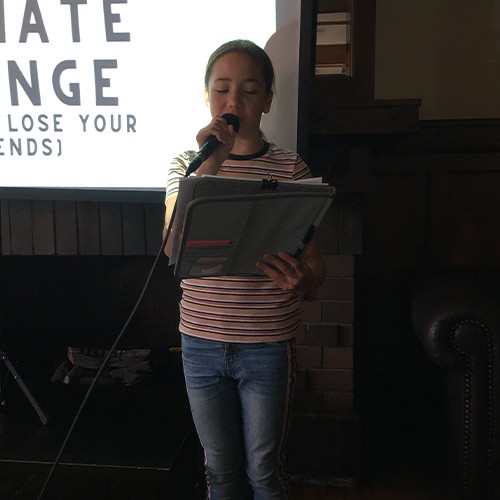 Bella reading outloud with a microphone