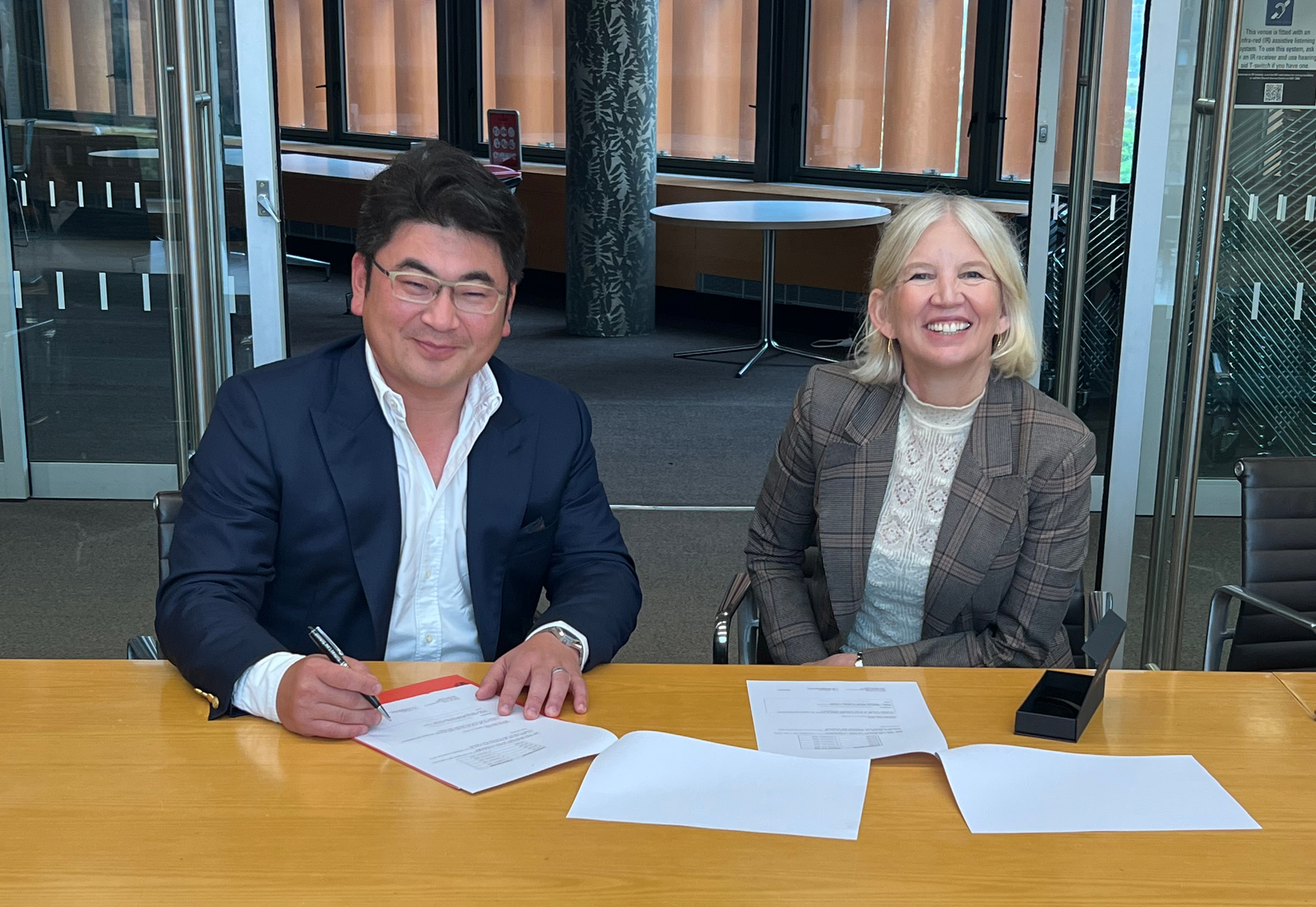 Sydney Law School Alumnus Steven Hu signs the Amberlake Scholarship documentation alongside SLS Dean Fleur Johns.