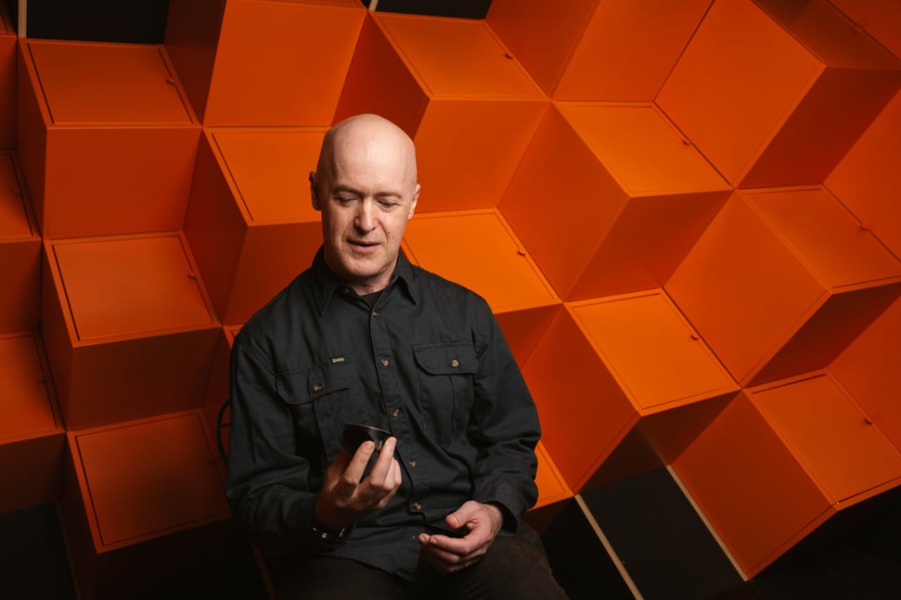 A man surrounded by orange, angular structures