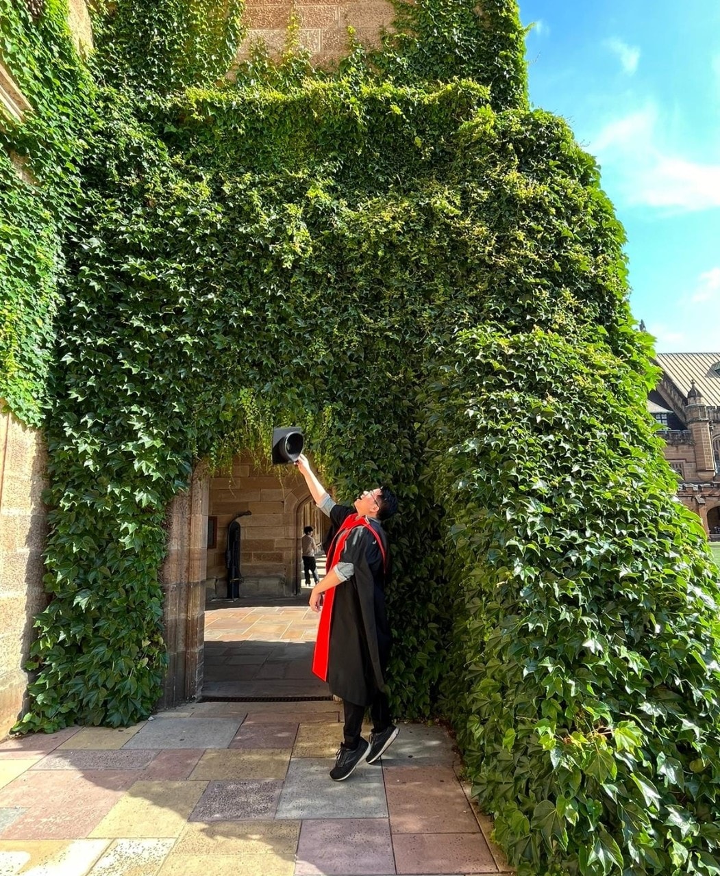 Dr Chieh-Ming Lai throwing doctoral tam into the air on graduation day at University of Sydney