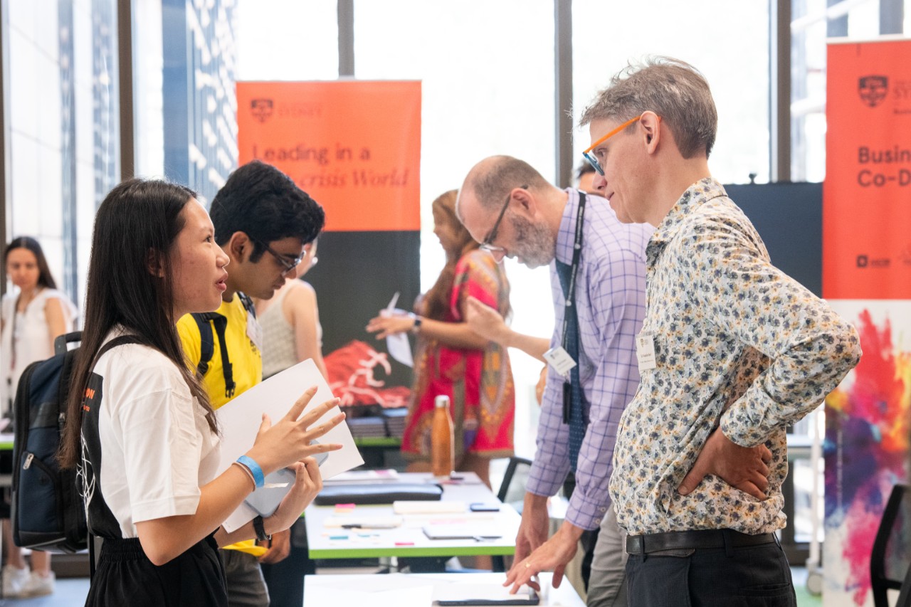A student and a teacher talking at an information booth